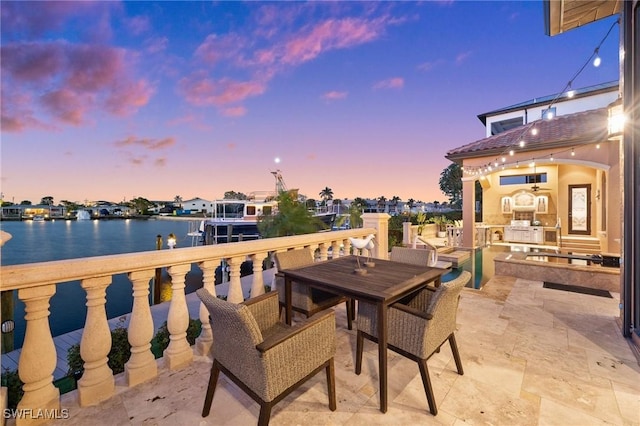 patio terrace at dusk featuring a water view