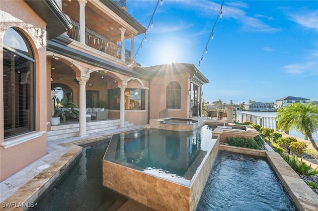 view of swimming pool featuring an in ground hot tub, a water view, a patio, and an outdoor living space