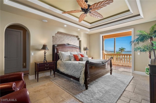 bedroom with a tray ceiling, ceiling fan, crown molding, and access to exterior