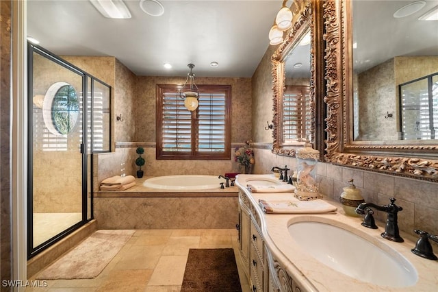 bathroom featuring independent shower and bath, tile walls, and vanity