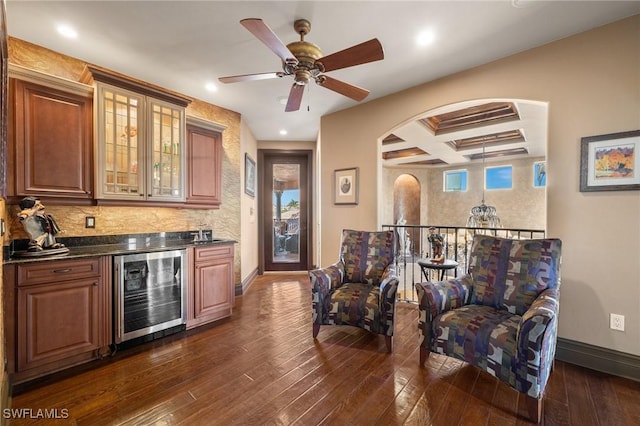 bar with coffered ceiling, beamed ceiling, dark stone counters, dark hardwood / wood-style floors, and wine cooler