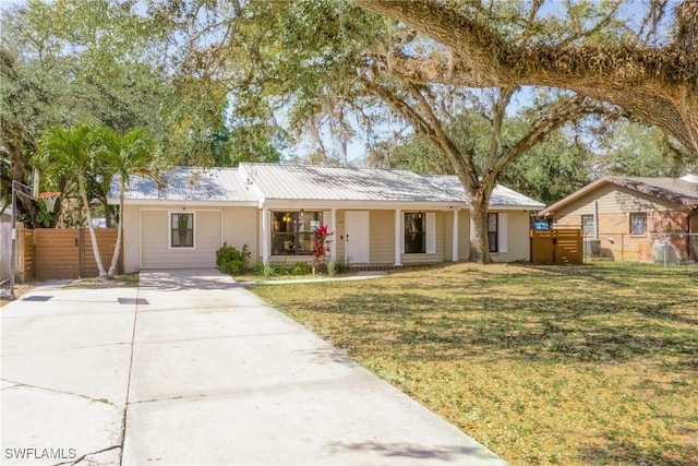 ranch-style home with a gate, metal roof, a front yard, and fence