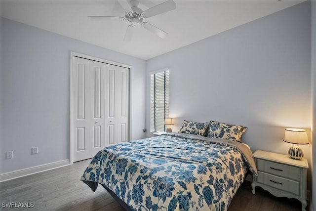 bedroom with dark wood-style floors, a closet, a ceiling fan, and baseboards