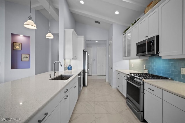 kitchen with appliances with stainless steel finishes, a sink, decorative light fixtures, and white cabinets