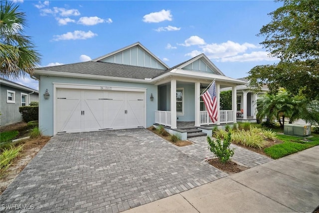 view of front of property featuring covered porch, a garage, decorative driveway, stucco siding, and board and batten siding