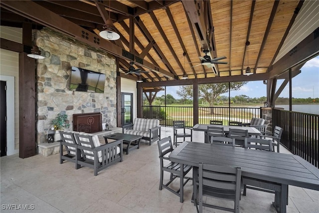 view of patio featuring ceiling fan, a water view, a gazebo, an outdoor living space with a fireplace, and outdoor dining space