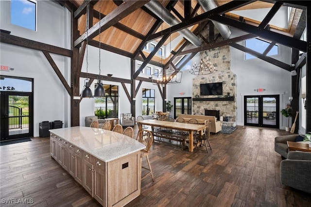 sunroom with a healthy amount of sunlight, an inviting chandelier, a fireplace, and beam ceiling