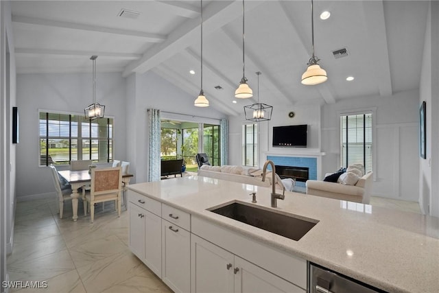 kitchen with hanging light fixtures, visible vents, open floor plan, and a sink