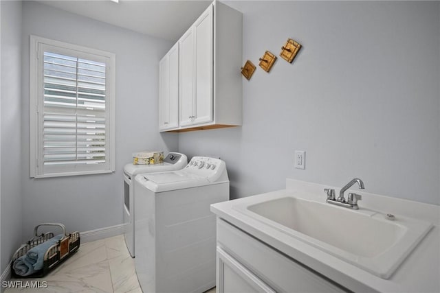 laundry area featuring marble finish floor, washing machine and clothes dryer, cabinet space, a sink, and baseboards