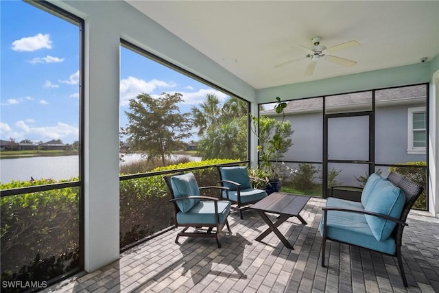 sunroom with a wealth of natural light, a water view, and ceiling fan