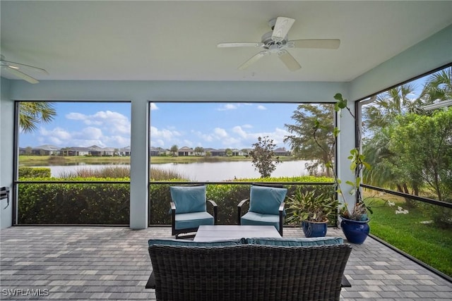 sunroom with a water view and ceiling fan