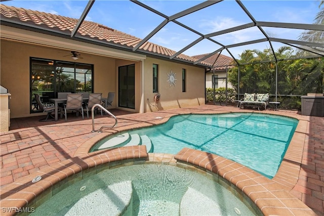 view of swimming pool featuring an in ground hot tub, ceiling fan, a patio, and glass enclosure