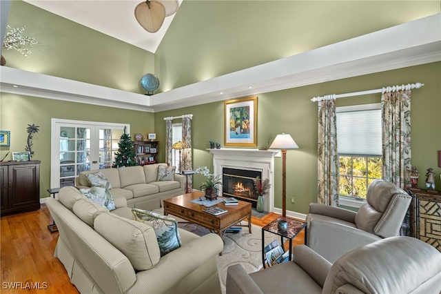 living room featuring high vaulted ceiling, light wood-type flooring, and french doors