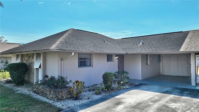 view of home's exterior with driveway, a shingled roof, and stucco siding