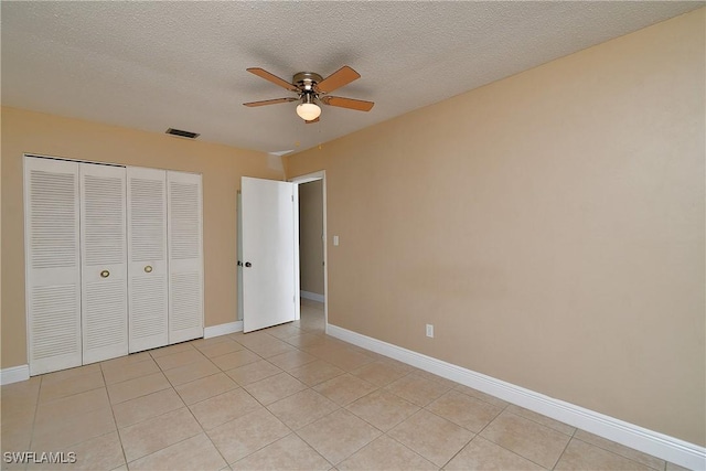 unfurnished bedroom with a closet, light tile patterned flooring, visible vents, and baseboards