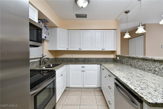 kitchen featuring stainless steel appliances, stone counters, a sink, and white cabinetry