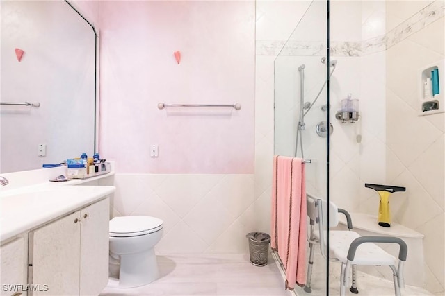 bathroom with tile walls, vanity, a tile shower, toilet, and radiator