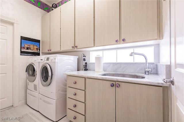 laundry area featuring sink, independent washer and dryer, and cabinets