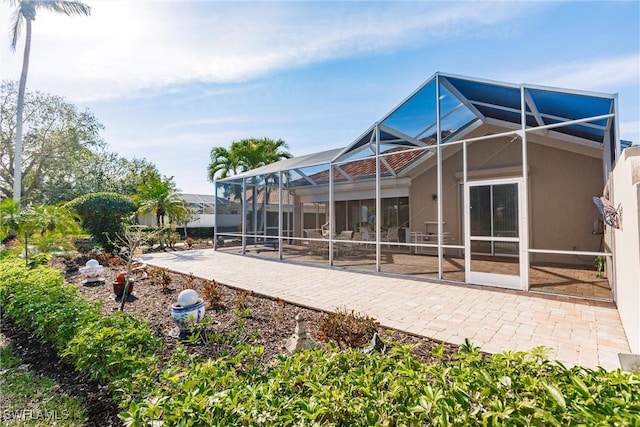 rear view of house featuring a lanai and a patio area