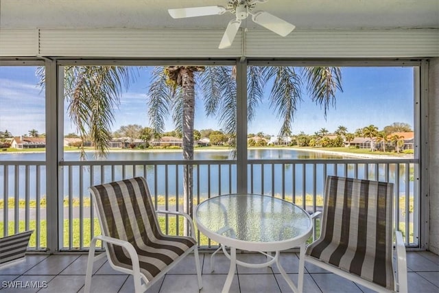 unfurnished sunroom featuring a water view and ceiling fan