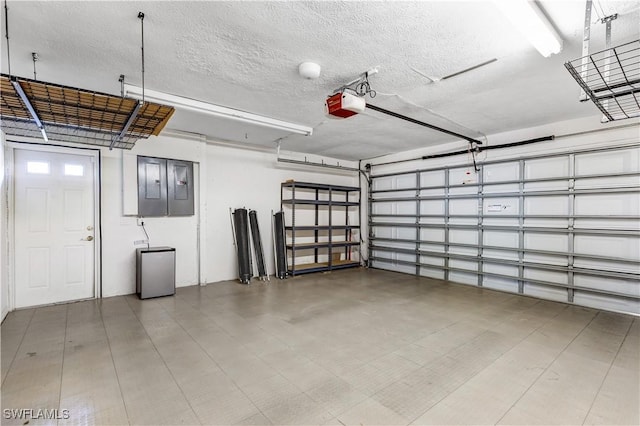 garage featuring fridge, electric panel, and a garage door opener