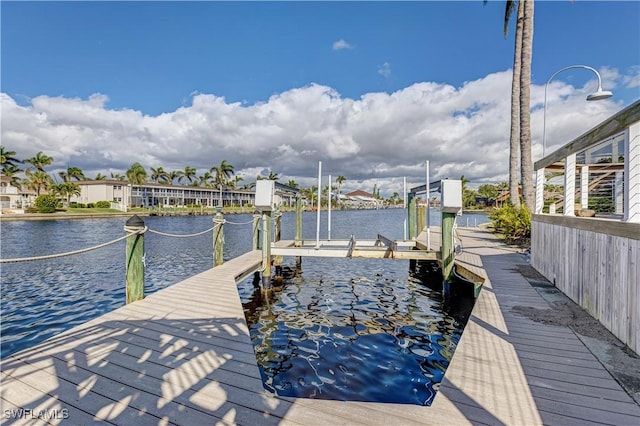 dock area with a water view and boat lift