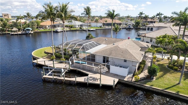 dock area featuring a residential view, a lanai, a water view, and a yard