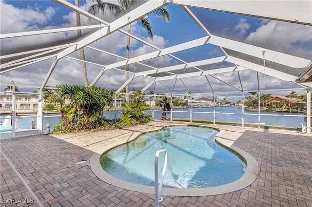 pool featuring a lanai, a water view, and a patio