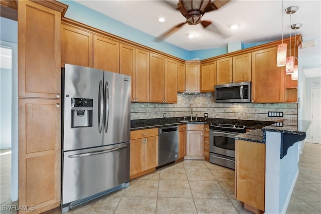 kitchen with light tile patterned floors, stainless steel appliances, tasteful backsplash, dark stone countertops, and a peninsula