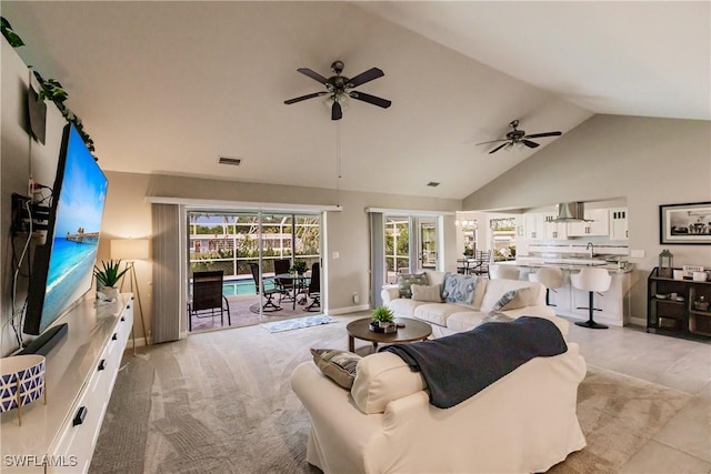 living room featuring ceiling fan, high vaulted ceiling, and light colored carpet