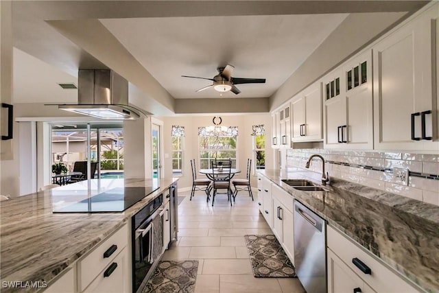 kitchen featuring appliances with stainless steel finishes, light stone counters, white cabinets, island exhaust hood, and sink