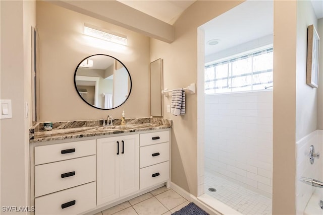 bathroom with vanity, tile patterned flooring, and tiled shower