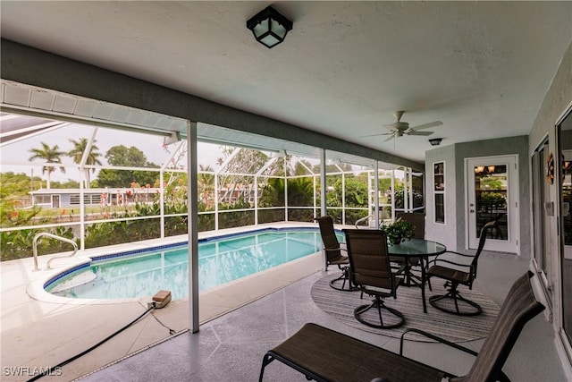 view of swimming pool with ceiling fan, a lanai, and a patio area