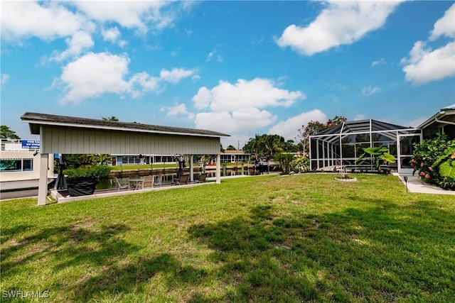 view of yard with glass enclosure and a water view