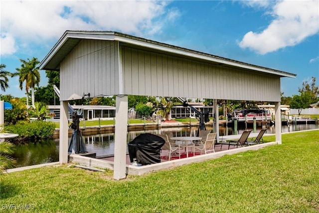 dock area with a lawn and a water view