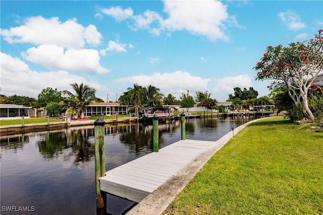 dock area with a yard and a water view