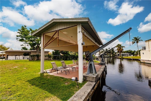 view of dock featuring a patio, a yard, and a water view