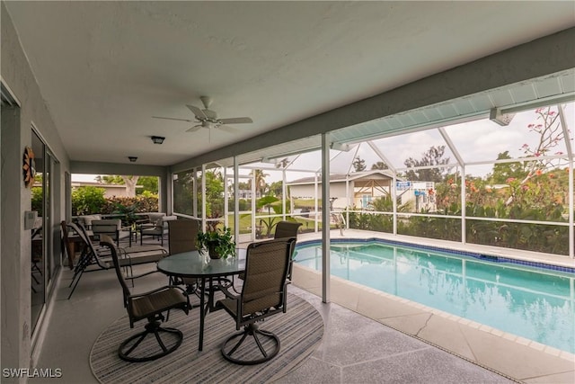 view of pool with glass enclosure and a patio area