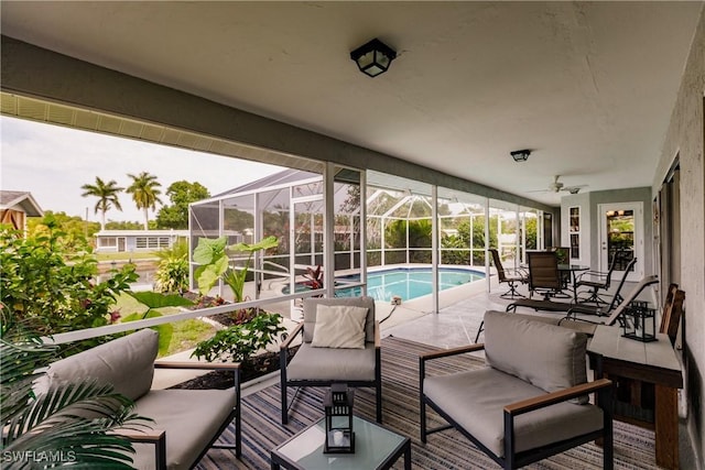 view of patio / terrace with an outdoor hangout area, glass enclosure, and ceiling fan