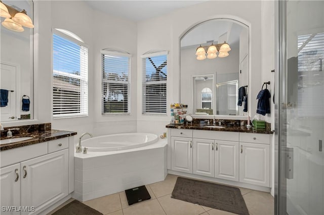 bathroom featuring a bath, a stall shower, tile patterned flooring, and a sink