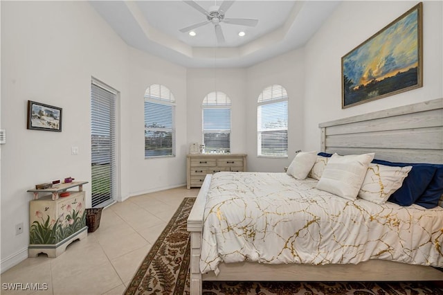 bedroom featuring light tile patterned floors, ceiling fan, recessed lighting, baseboards, and a tray ceiling