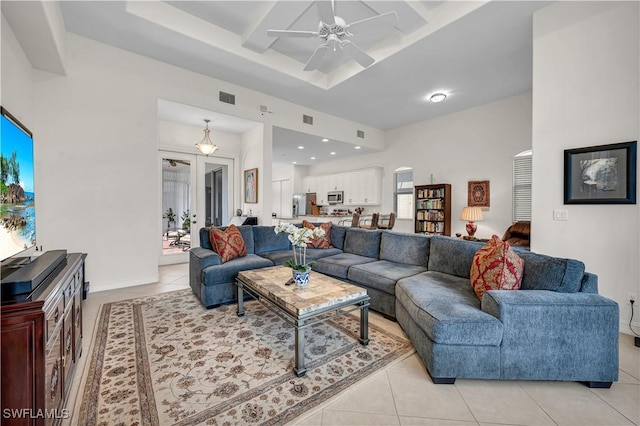 living area with light tile patterned floors, visible vents, coffered ceiling, a ceiling fan, and beam ceiling