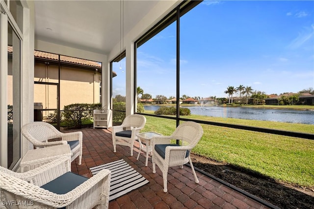 sunroom featuring a water view