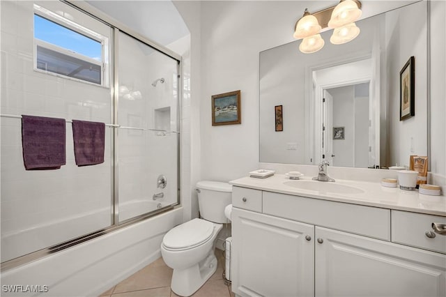 bathroom featuring vanity, shower / bath combination with glass door, tile patterned flooring, and toilet