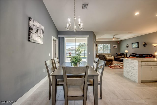 dining space featuring light tile patterned floors, visible vents, vaulted ceiling, baseboards, and ceiling fan with notable chandelier