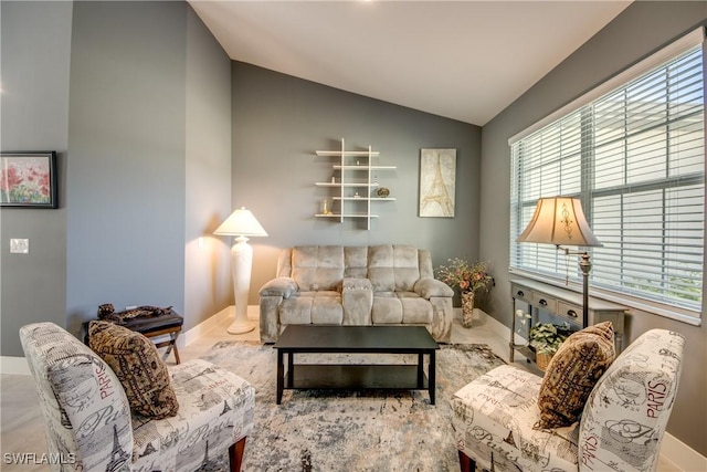 living room featuring lofted ceiling and baseboards