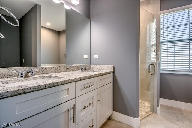 full bathroom featuring a shower stall, baseboards, and a sink