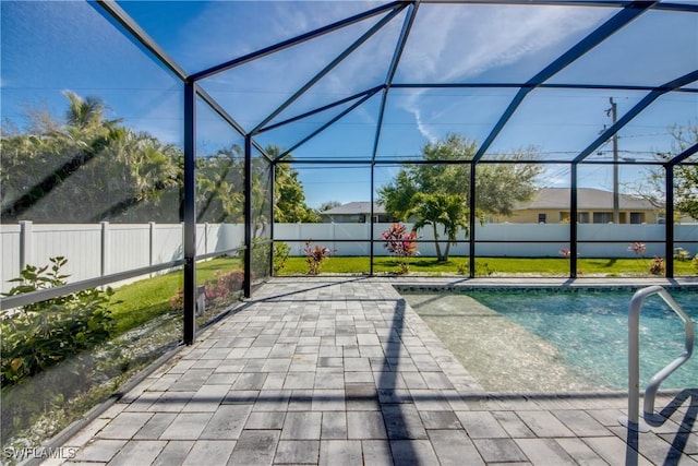 view of pool with a patio, a fenced backyard, glass enclosure, and a fenced in pool