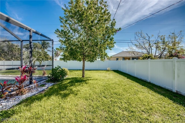 view of yard featuring a fenced backyard and a lanai