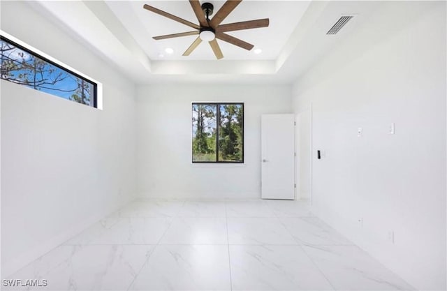 spare room featuring ceiling fan and a tray ceiling